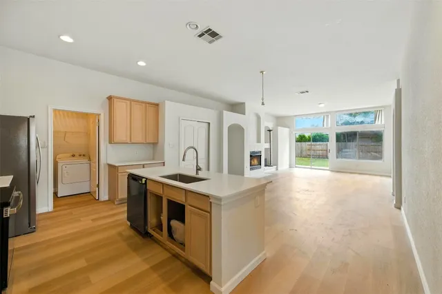 a view of a kitchen with a sink and a refrigerator