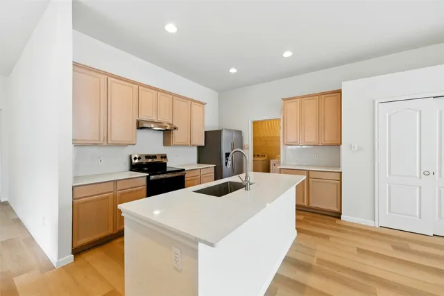 a kitchen with a stove a refrigerator and a sink