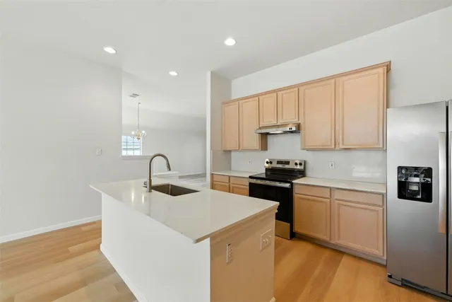 a kitchen with a sink a stove and cabinets