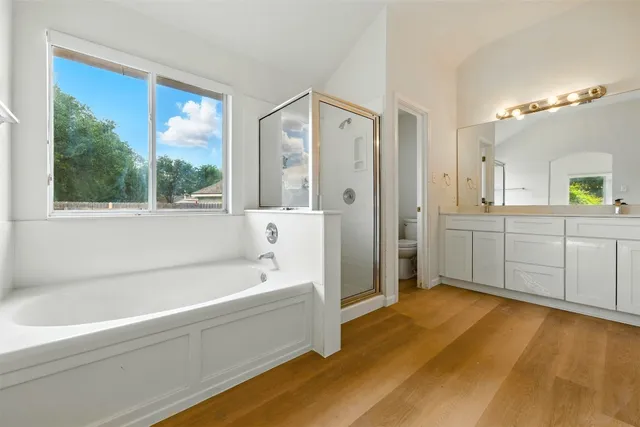 a bathroom with a tub sink and mirror