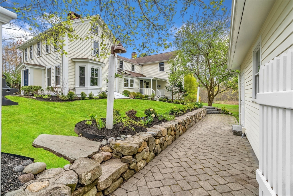 a very nice looking house with a big yard and potted plants