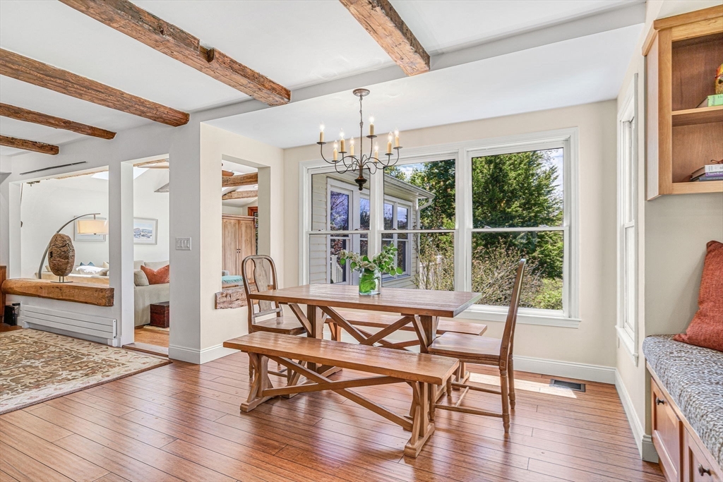 34 Everett Street Natick, MA 01760 - Photo 10 of 34 a dining room with wooden floor a chandelier a glass table and chairs