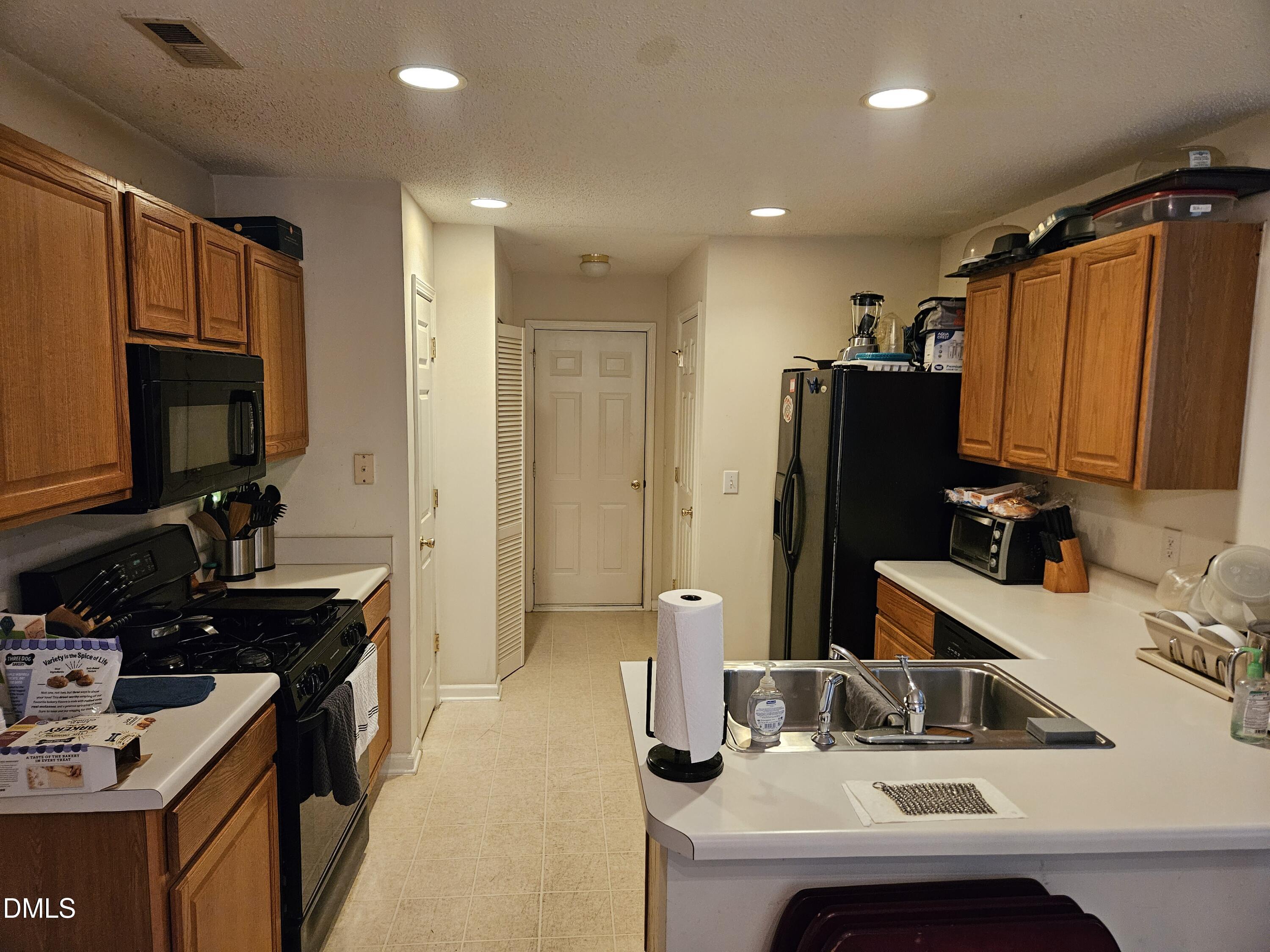5201 Golden Moss Trail Raleigh, NC 27613 - Photo 8 of 10 a kitchen with kitchen island granite countertop a sink stove and refrigerator