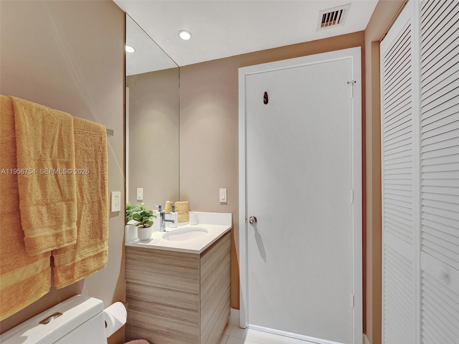 121 Northeast 34th Street, Unit 2106A Miami, FL 33137 - Photo 23 of 59 a bathroom with a shower curtain and a sink