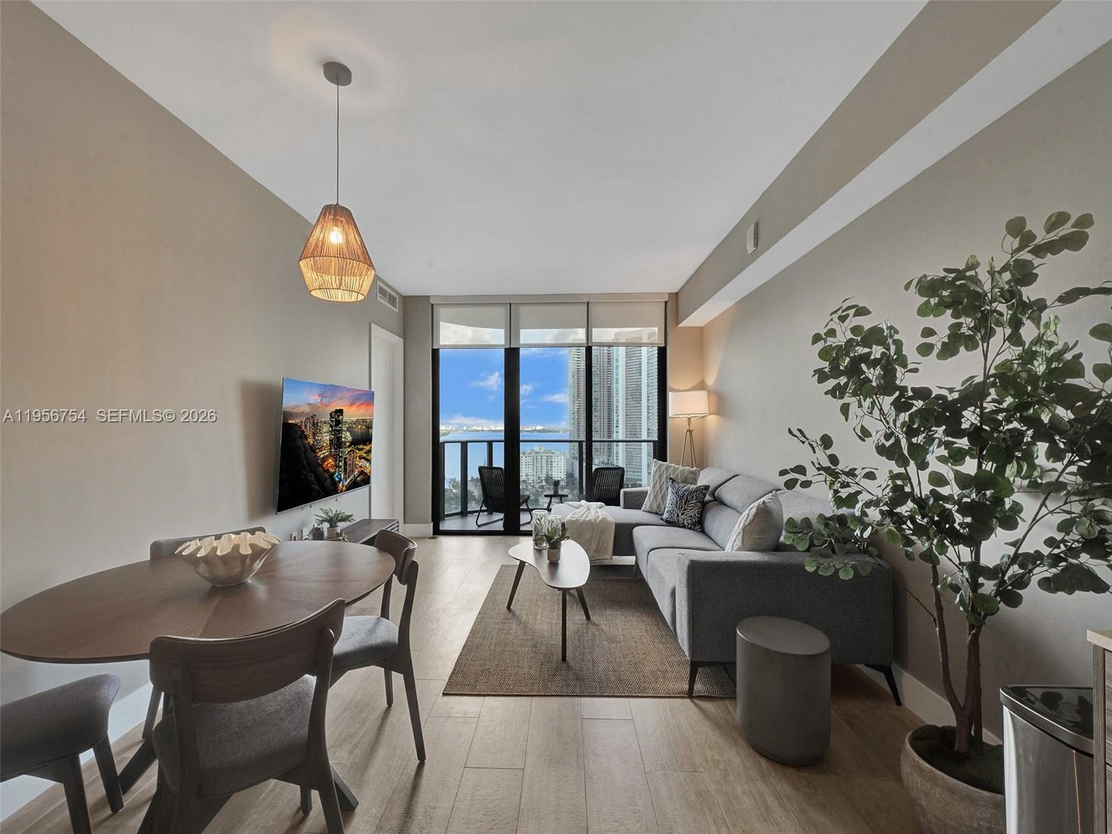121 Northeast 34th Street, Unit 2106A Miami, FL 33137 - Photo 9 of 59 a living room with furniture potted plant and a large window