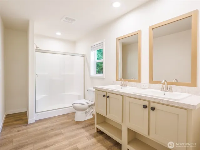 a bathroom with a double vanity sink toilet mirror and bathtub