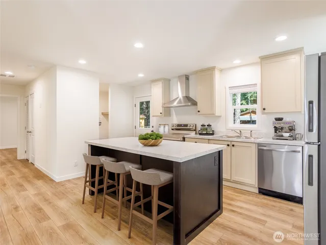a kitchen with kitchen island a sink table and chairs