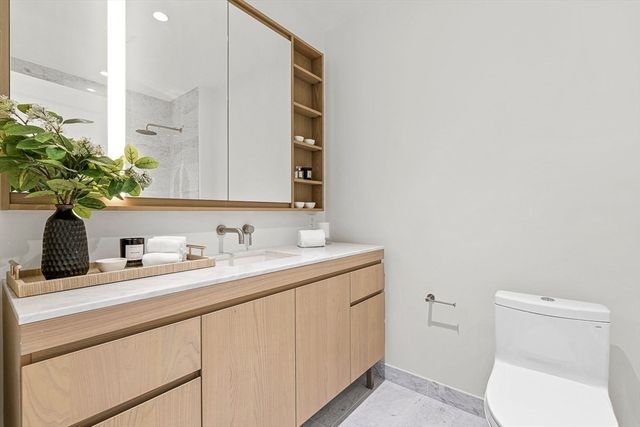 a bathroom with a toilet sink and mirror