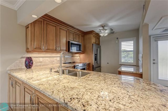 a kitchen with stainless steel appliances granite countertop a sink refrigerator and microwave