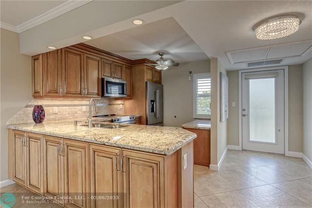 a kitchen with stainless steel appliances granite countertop a refrigerator stove and sink