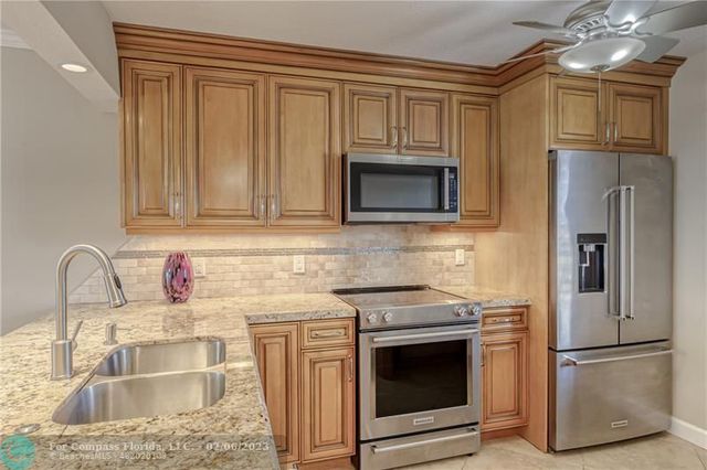 a kitchen with stainless steel appliances granite countertop a sink stove and microwave