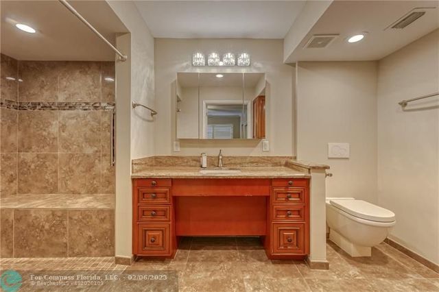 a bathroom with a granite countertop sink a mirror and shower