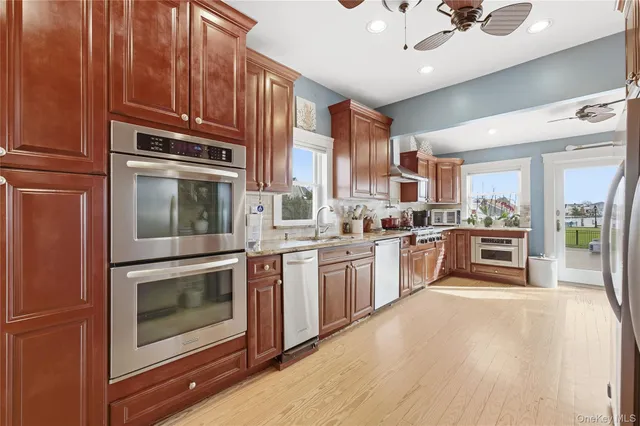a kitchen with stainless steel appliances granite countertop a stove a sink and a refrigerator