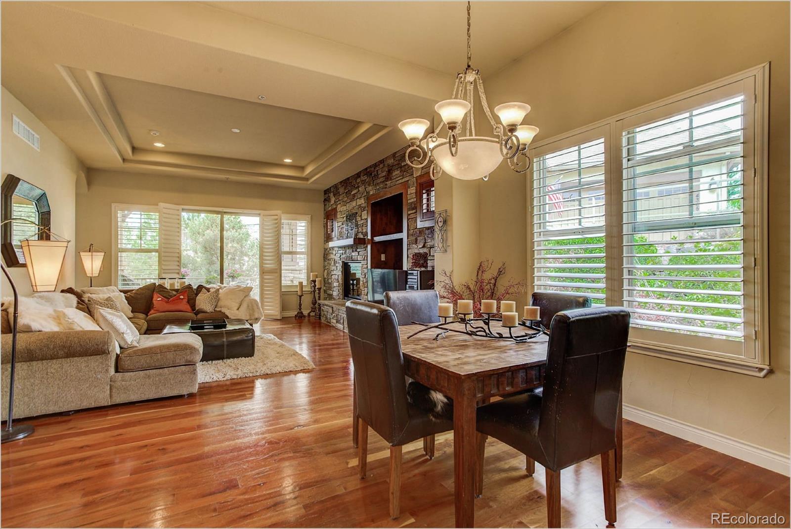 4363 Chateau Ridge Lane Castle Rock, CO 80108 - Photo 16 of 32 a dining room with furniture a chandelier and wooden floor