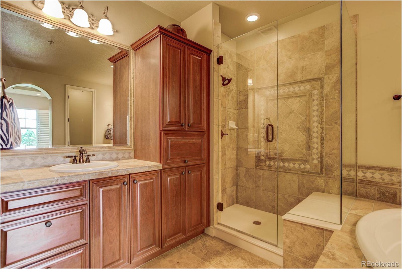 4363 Chateau Ridge Lane Castle Rock, CO 80108 - Photo 20 of 32 a bathroom with a double vanity sink toilet and shower