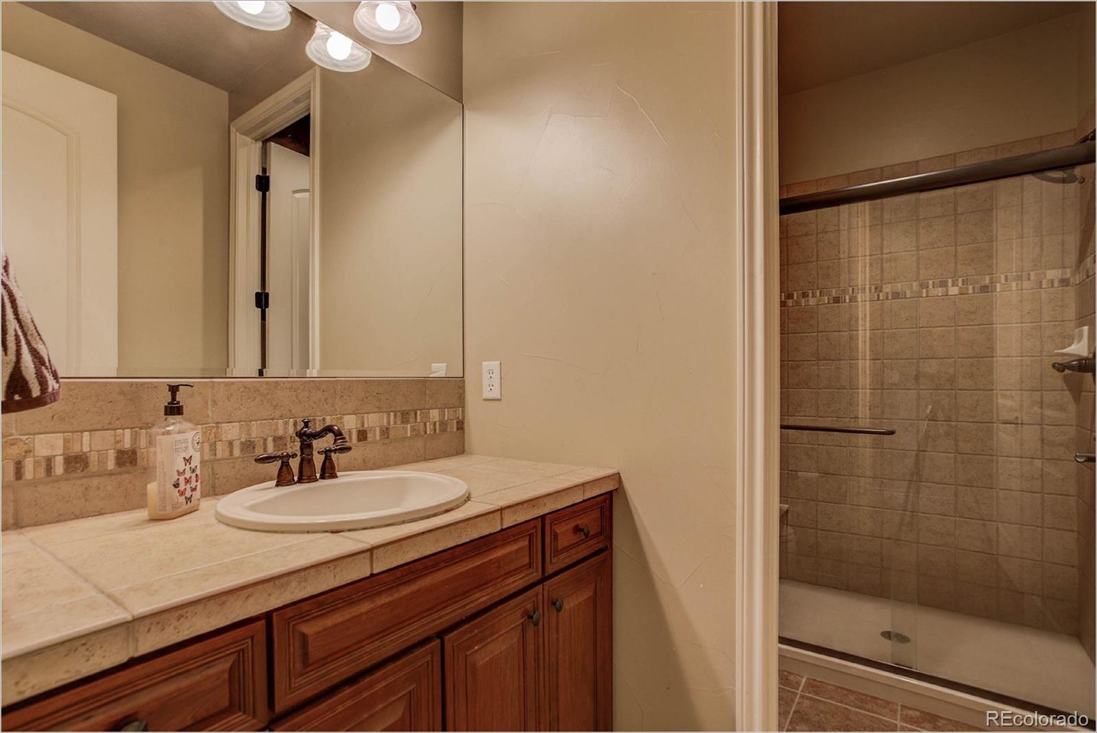 4363 Chateau Ridge Lane Castle Rock, CO 80108 - Photo 25 of 32 a bathroom with a sink and a mirror