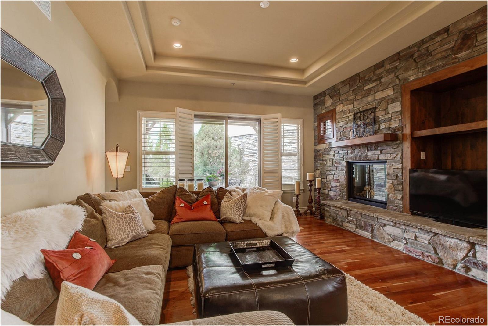4363 Chateau Ridge Lane Castle Rock, CO 80108 - Photo 10 of 32 a living room with furniture tv and a fireplace