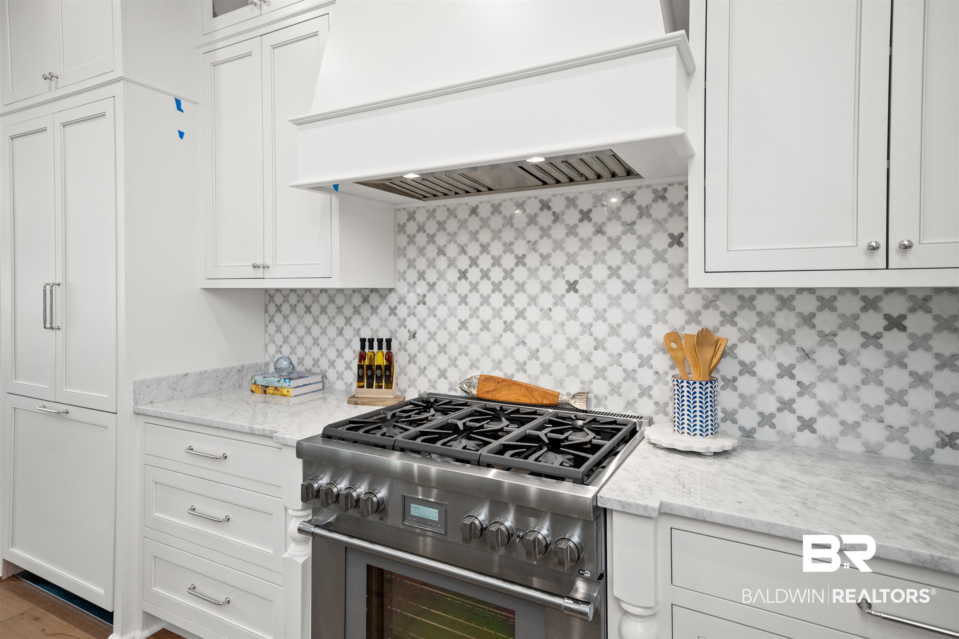 156 Hyacinth Street Fairhope, AL 36532 - Photo 14 of 61 Kitchen featuring custom range hood, high end stove, tasteful backsplash, and white cabinetry
