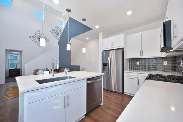 a kitchen with a sink a refrigerator and cabinets
