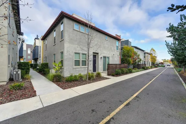 a front view of a house with a yard and potted plants