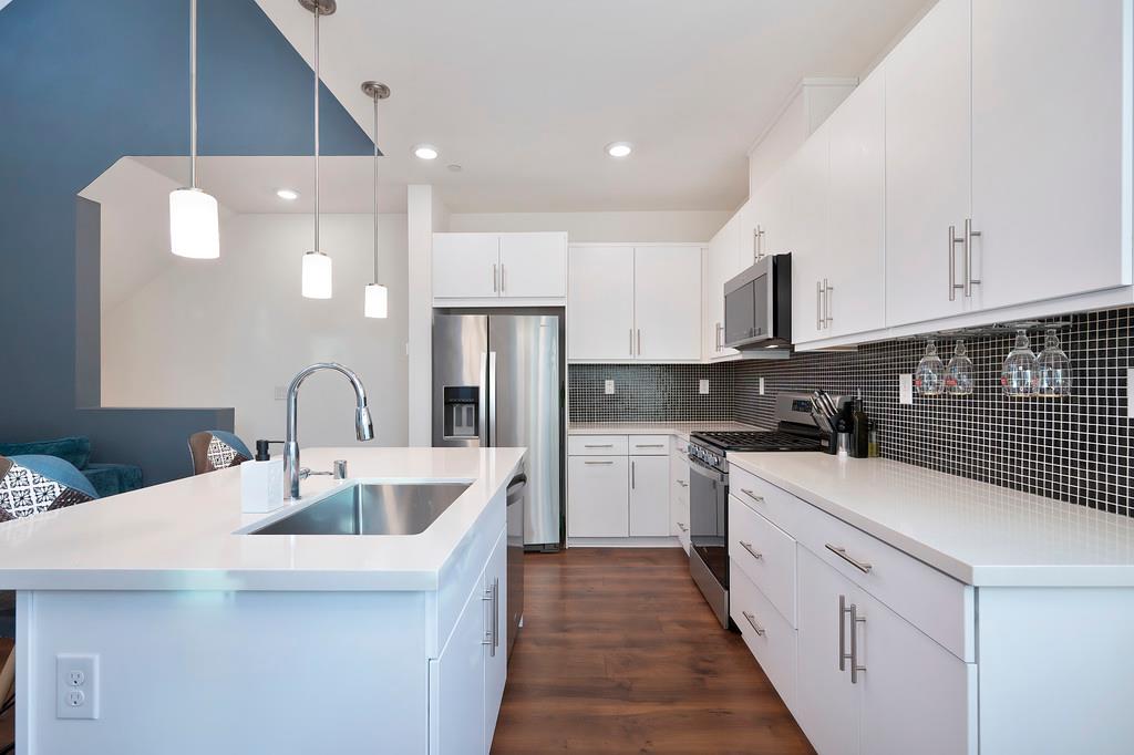 216 Box Lane Sacramento, CA 95818 - Photo 4 of 37 a kitchen with stainless steel appliances a sink dishwasher a refrigerator oven and white cabinets with wooden floor