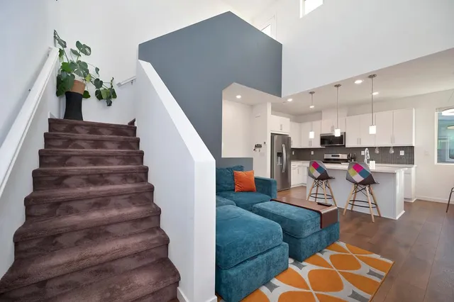 a living room with furniture and a dining table with wooden floor