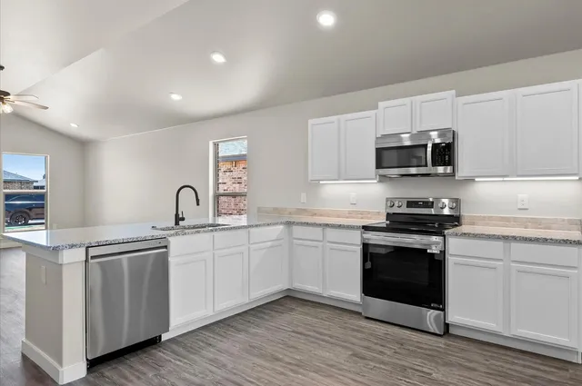 a kitchen with stainless steel appliances granite countertop a sink and stove top oven