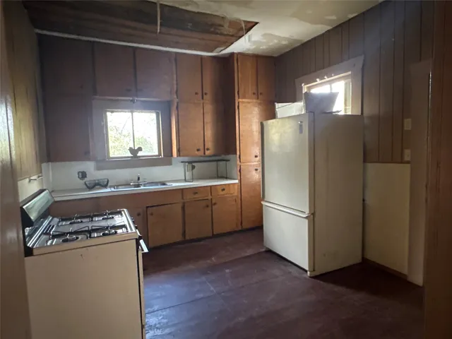 a kitchen with a refrigerator a stove a sink and a window