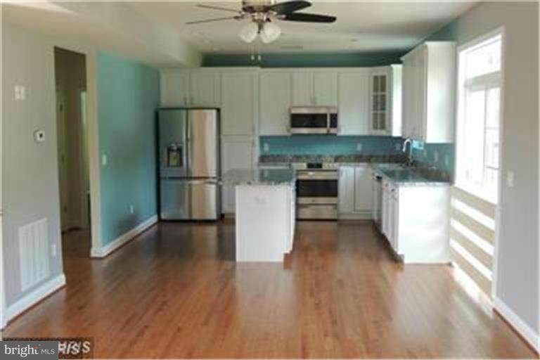 5952 Tyler Road Deale, MD 20751 - Photo 5 of 21 a kitchen with white cabinets and stainless steel appliances