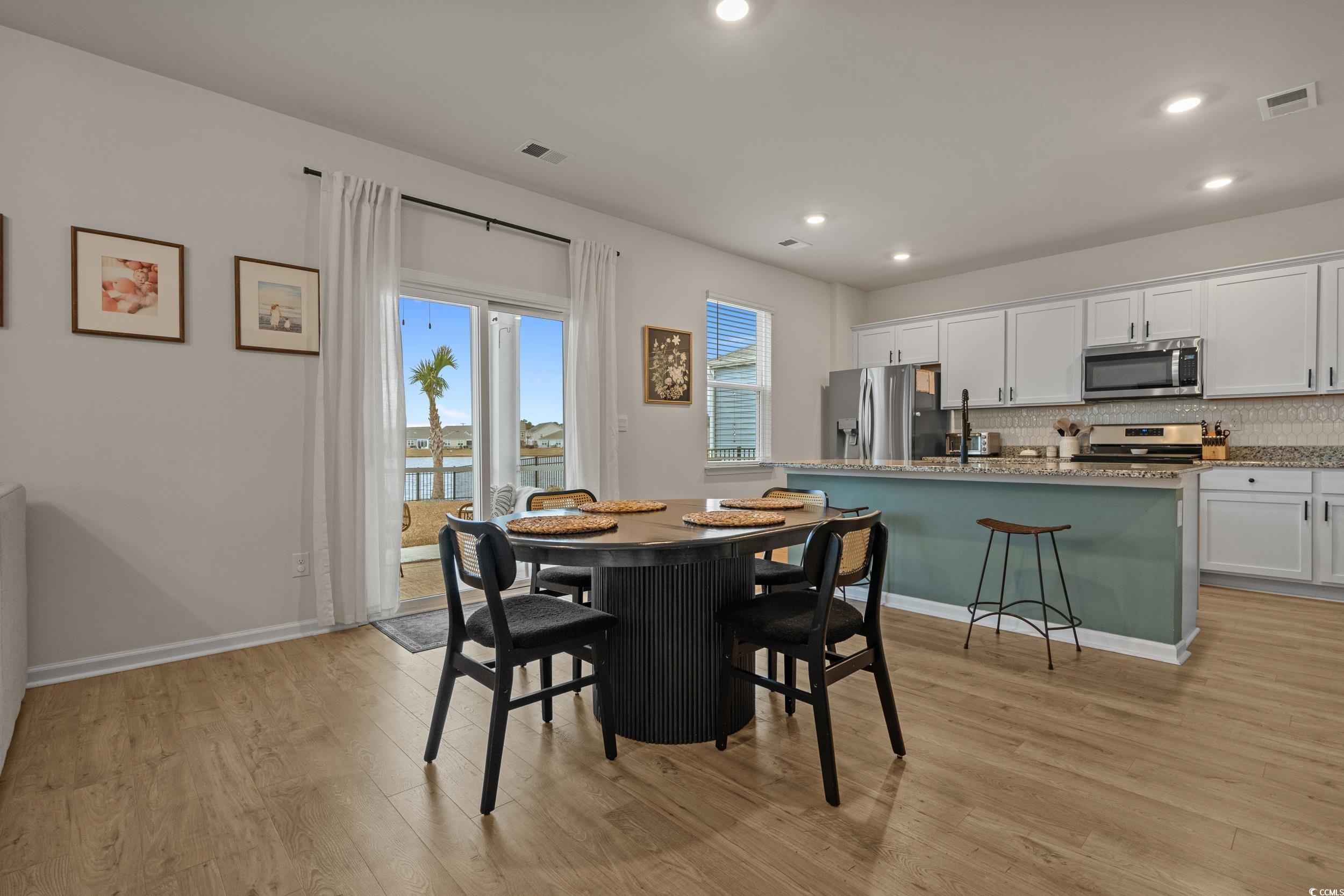 3343 Bells Lake Circle Longs, SC 29568 - Photo 11 of 40 Dining space with light wood-type flooring, a water view, and recessed lighting