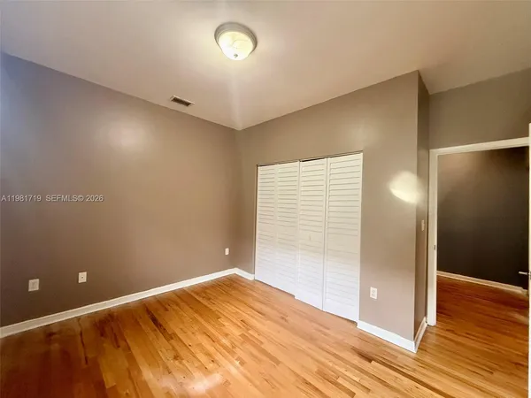 an empty room with wooden floor and entrance