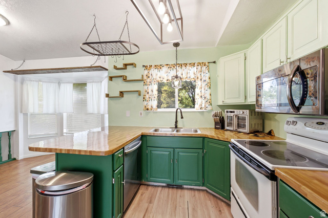 2475 Church Street Layton, UT 84040 - Photo 6 of 27 Kitchen featuring wood-finish flooring, wood countertops, and green lower cabinetry