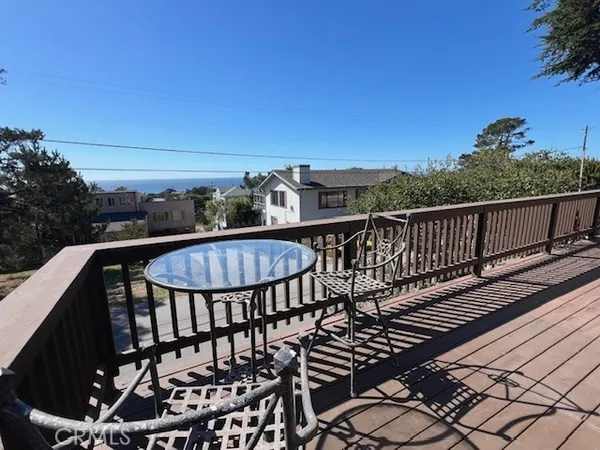 a room with a bed and a dresser next to a window