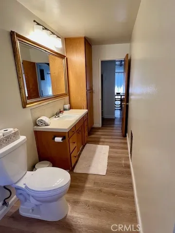 a spacious bedroom with a bed a dresser and window