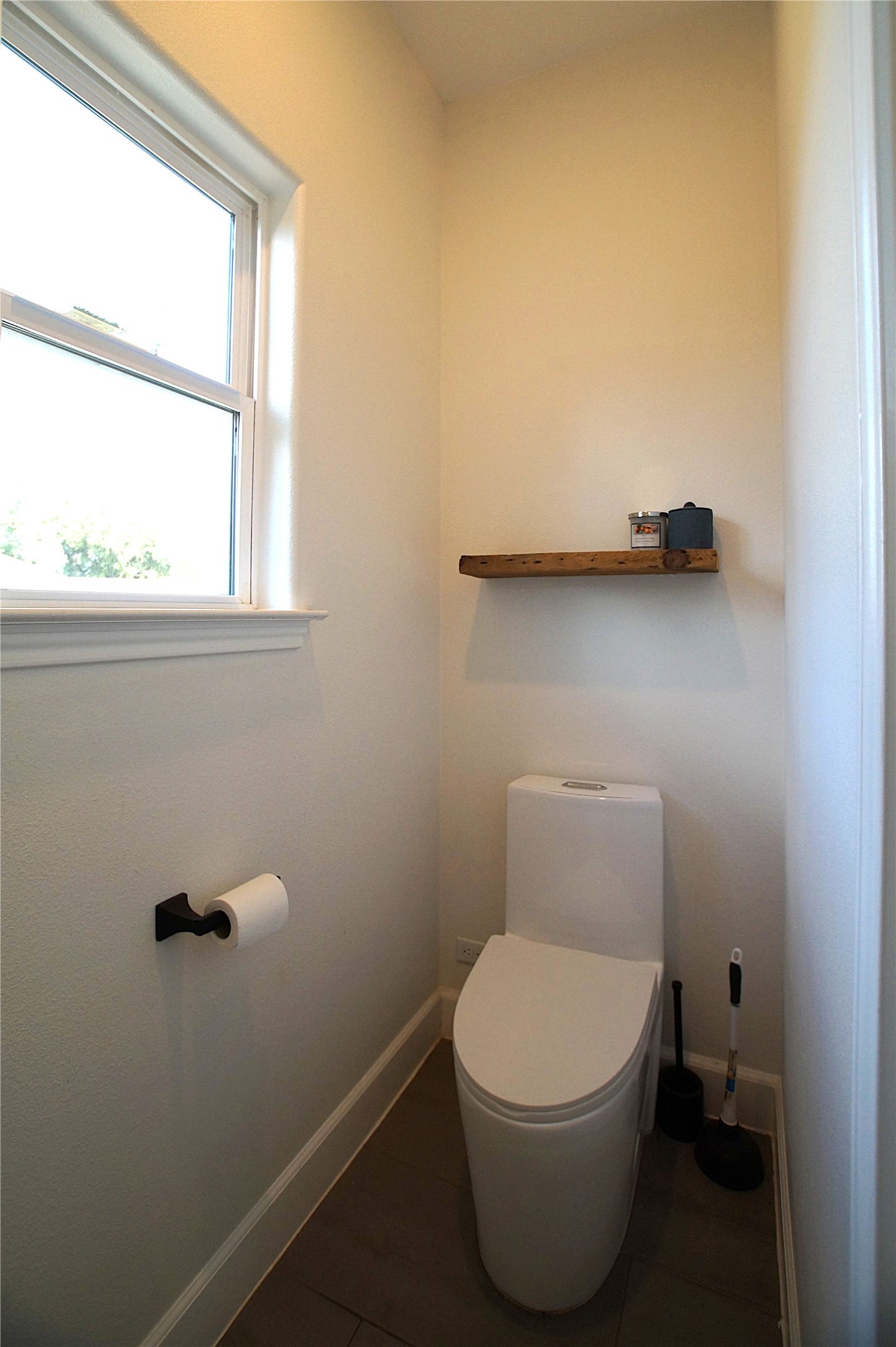 20602 Oak Ridge Lago Vista, TX 78645 - Photo 20 of 35 Natural light streams through a large window into this bath, featuring dual flush modern toilet and tiled flooring.