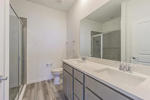 a bathroom with a sink a toilet a shower and a mirror