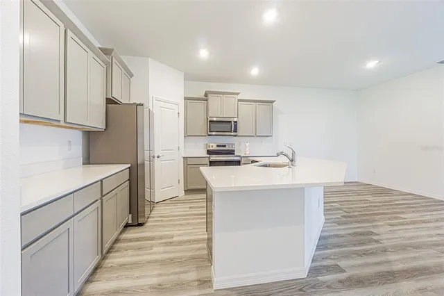 a kitchen with stainless steel appliances granite countertop a refrigerator and a stove top oven