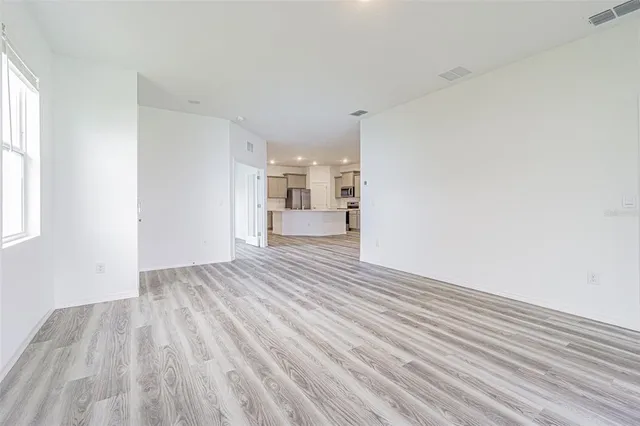 a view of empty room with wooden floor