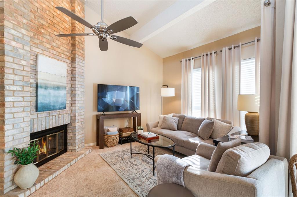 a living room with furniture a fireplace and a window