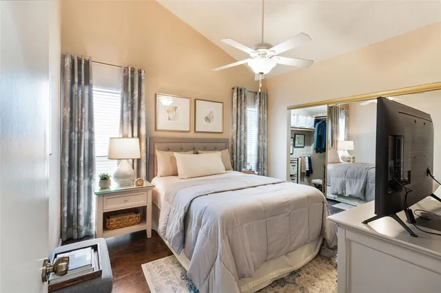 a bedroom with a bed and a mirror on the dresser