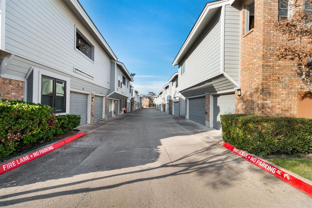 17490 Meandering Way, Unit 804 Dallas, TX 75252 - Photo 28 of 33 a view of a white house with small yard plants and large tree