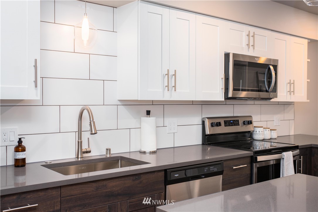 1880 Front Street, Unit 206 Lynden, WA 98264 - Photo 11 of 30 a kitchen with stainless steel appliances granite countertop a sink stove and microwave