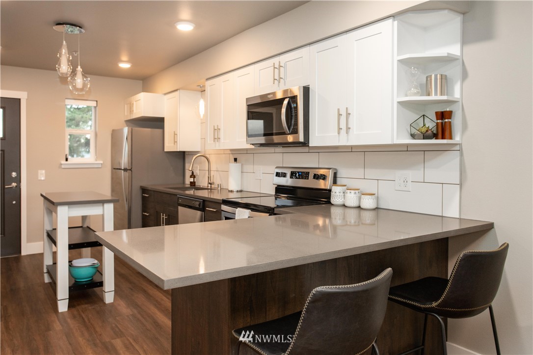 1880 Front Street, Unit 206 Lynden, WA 98264 - Photo 9 of 30 a kitchen with stainless steel appliances a stove a sink a microwave a refrigerator and cabinets