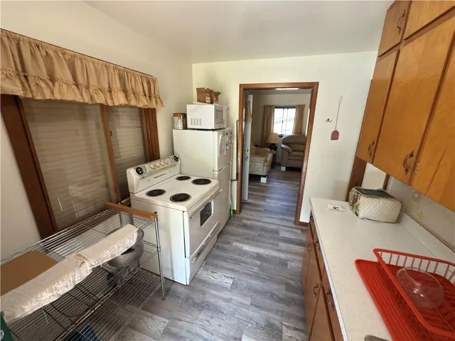 a kitchen with sink a refrigerator and wooden floor