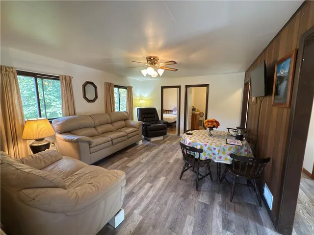 a living room with furniture two window and wooden floor