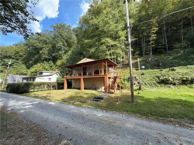 a view of a house with backyard and trees