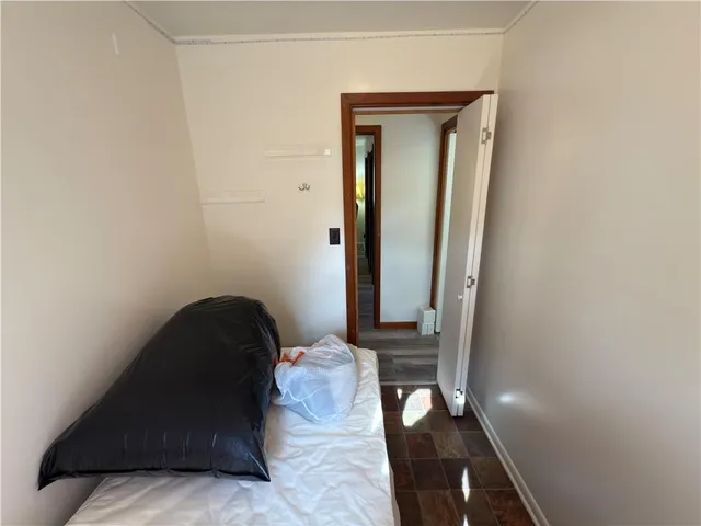 a view of a hallway with wooden floor and a bathroom