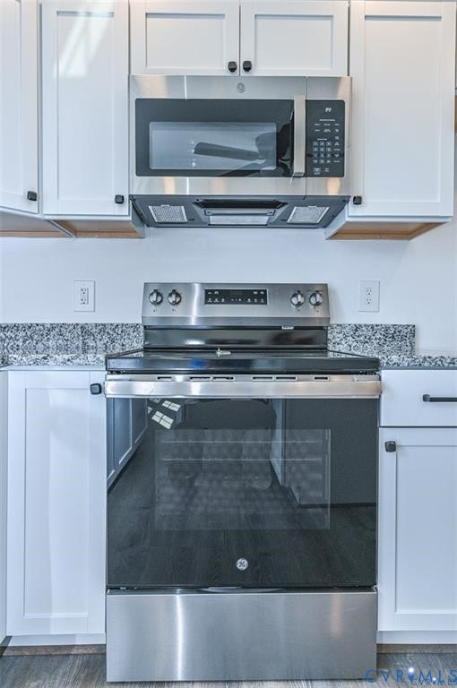 993 Swan Lane Ruther Glen, VA 22546 - Photo 11 of 31 a kitchen with a stove and white cabinets