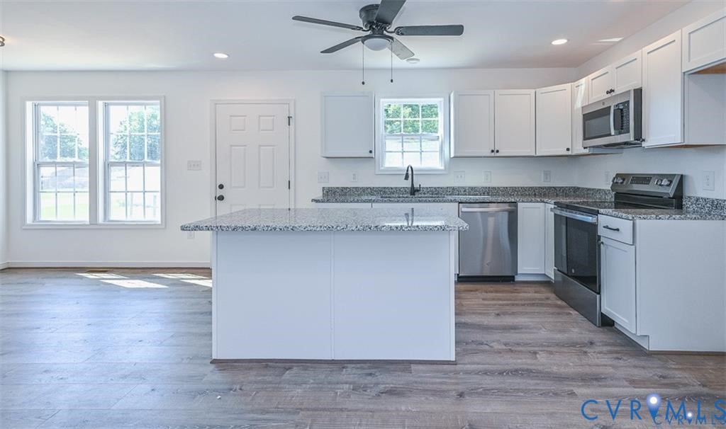 993 Swan Lane Ruther Glen, VA 22546 - Photo 7 of 31 a kitchen with stainless steel appliances granite countertop a stove a sink and a microwave