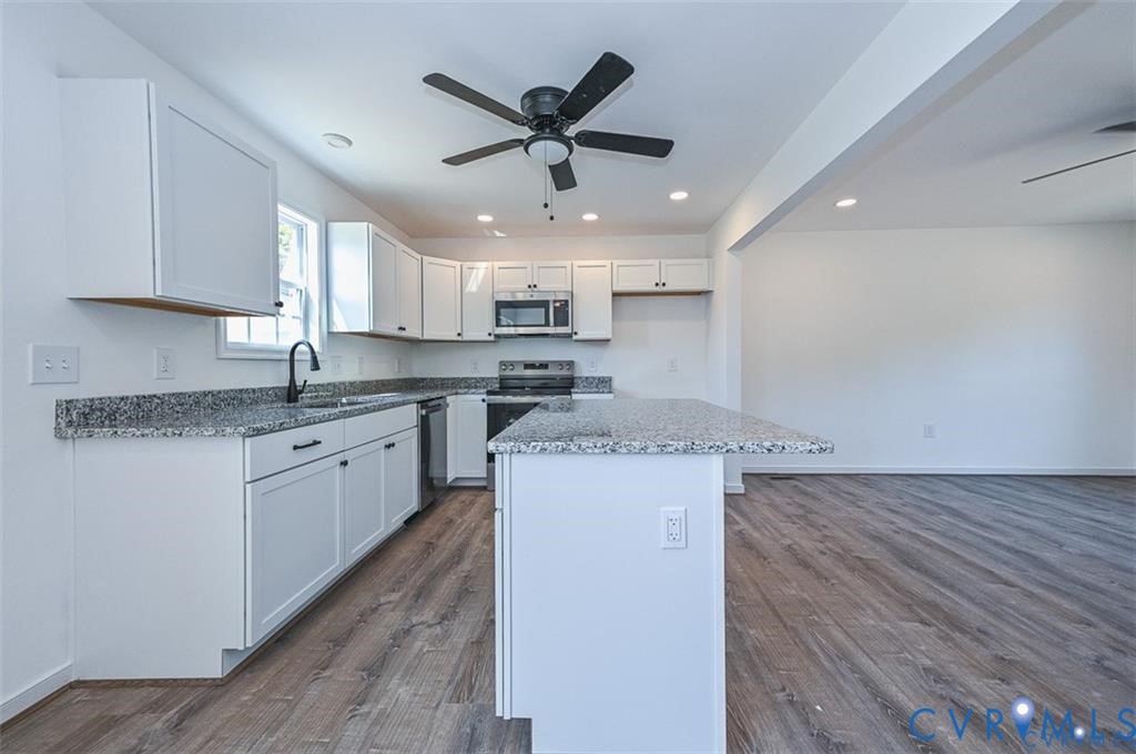 993 Swan Lane Ruther Glen, VA 22546 - Photo 8 of 31 a kitchen with stainless steel appliances granite countertop a sink a stove a refrigerator and island with wooden floor